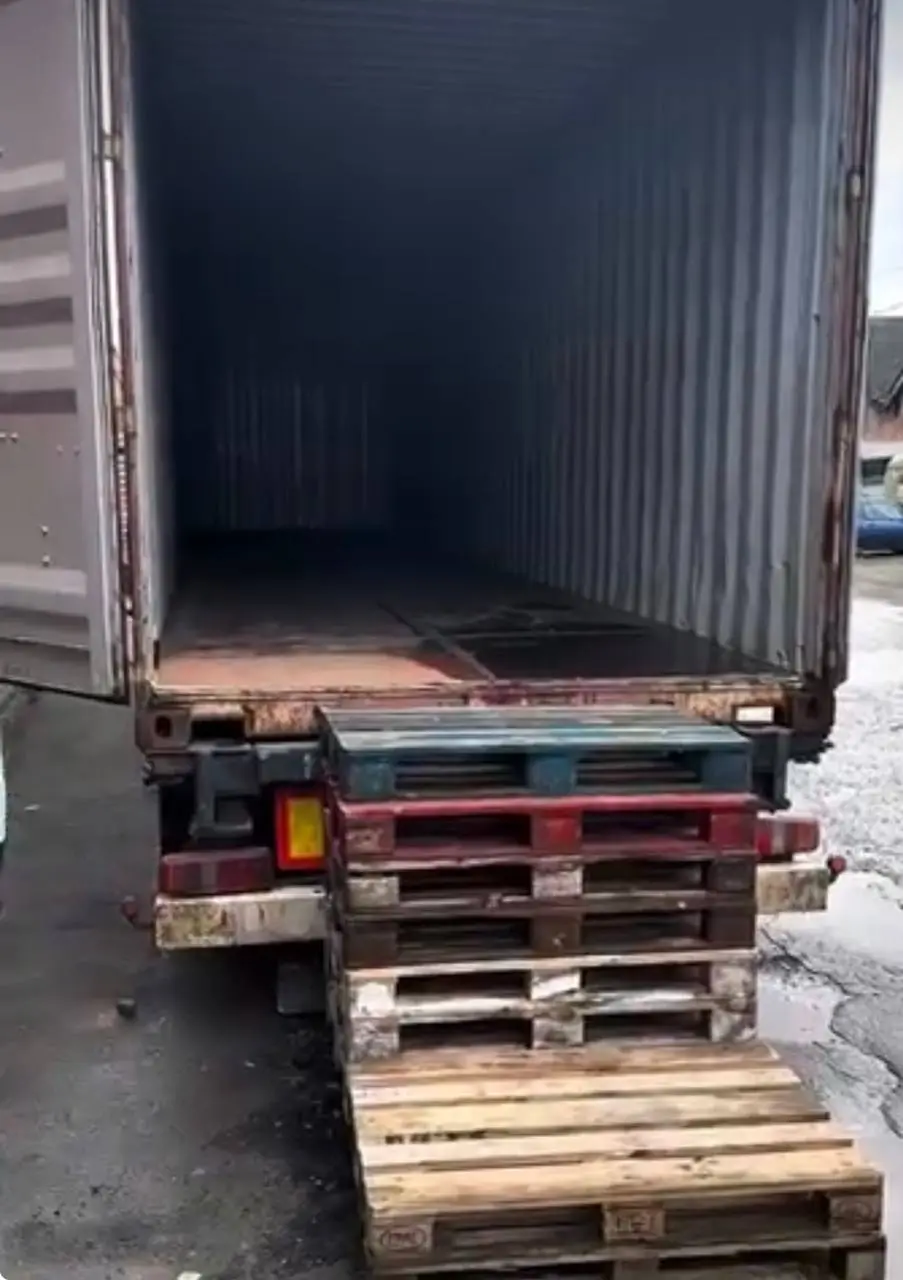 Conteneur ouvert et palettes en bois prêts pour le chargement